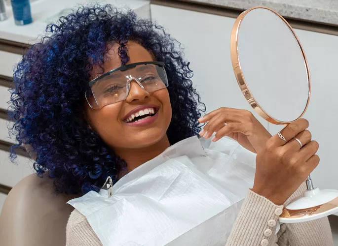 Woman smiling and looking in mirror